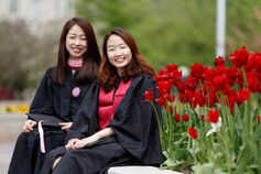 Two smiling students in graduation caps and gowns